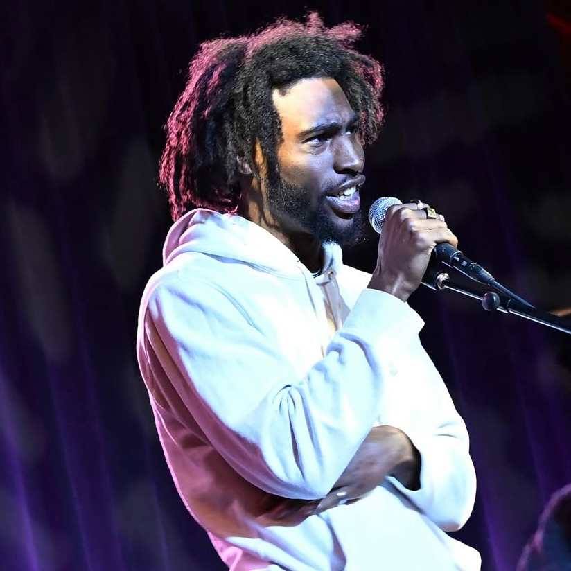 Performer holding a microphone on stage.